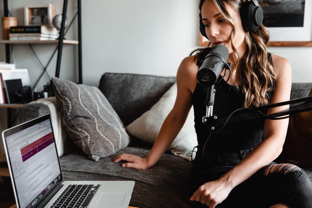 a woman recording a podcast ad