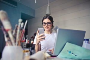 woman in white shirt using smart phone