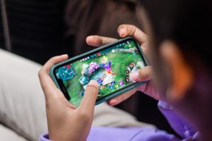 Person playing mobile game on hand held device